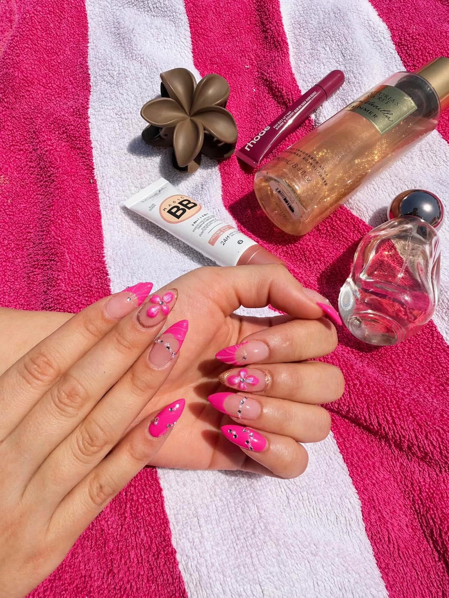 Bright pink custom nail art with flowers and crystals by Aphrodite Beauty Salon
