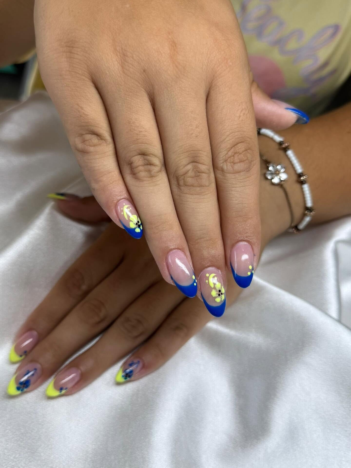 Blue and yellow French tip nails with hibiscus art